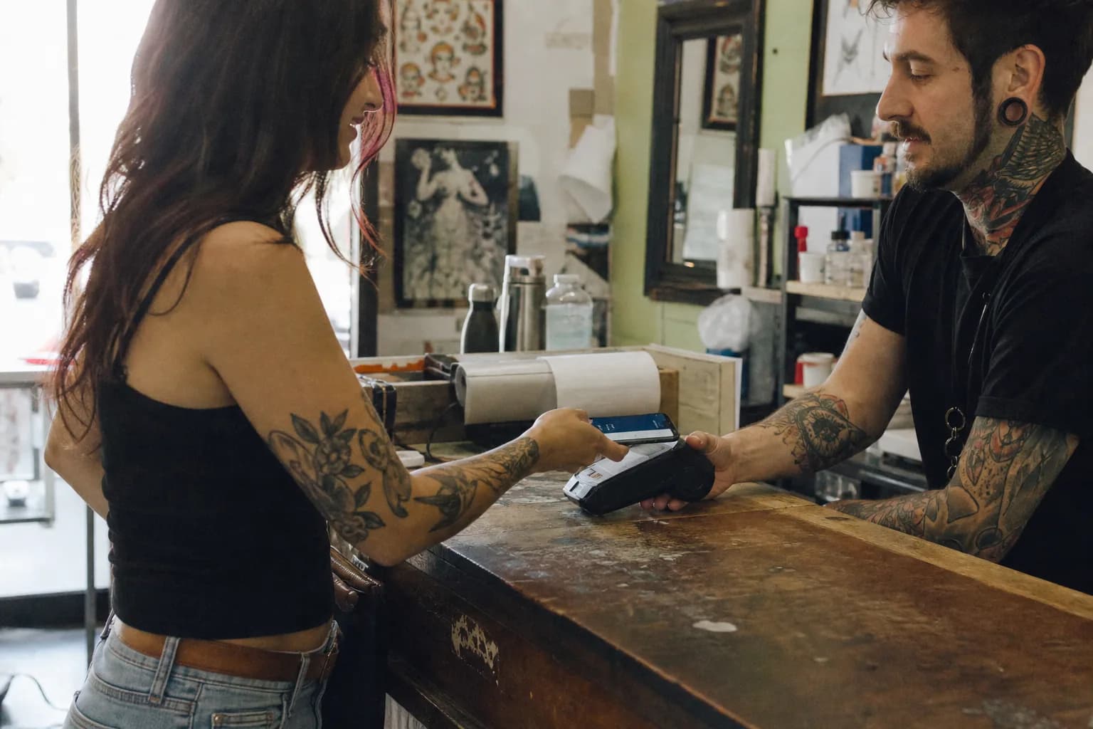 Client paying at the tattoo shop front desk